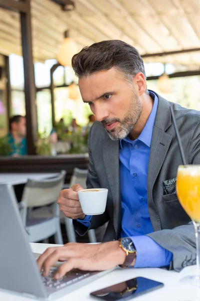 Restoranda Dizüstü Bilgisayarıyla Çalışan Yakışıklı Bir Adamı — Stok fotoğraf
