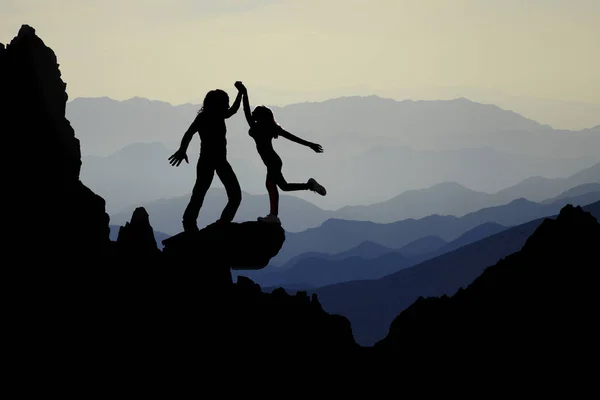 Teamwork couple celebrating in inspiring mountains sunset