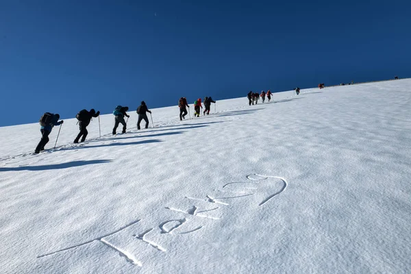 climbers walking on snow in challenging and sloping mountains