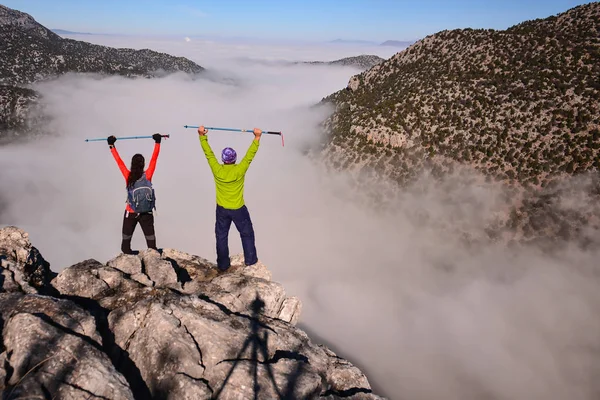 Two climbers on top of foggy mountains