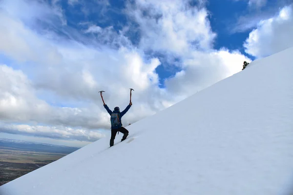 Вершина снежных гор и альпинист на скалах — стоковое фото