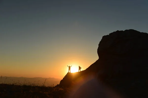 successful climb on top of mountains at sunrise