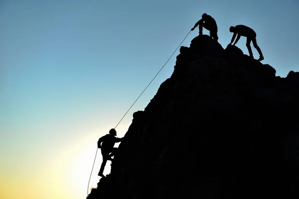 Man climbing on rock with rope support — Stock Photo, Image