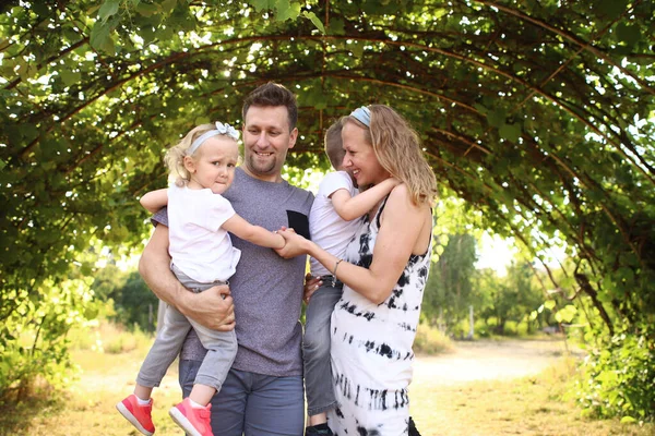 Feliz familia amorosa con dos hijos, hijo e hija jugando y abrazándose. Caminata familiar. Feliz Día de las Madres. — Foto de Stock