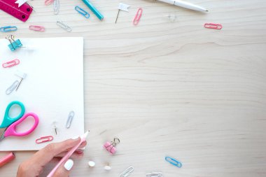 Ahşap arka planda okul malzemeleri. Okul konseptine geri dönelim. Kopya alanı için elleri olan beyaz tahta. Üst görünüm tasarımınız için hazır