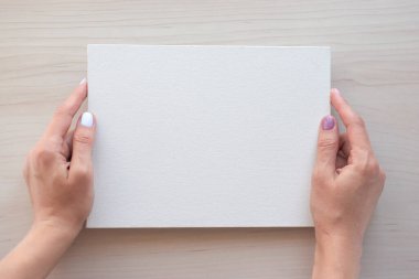 Kopya alanı için elleri olan beyaz tahta. Ahşap arka planda okul malzemeleri. Okul konseptine geri dönelim. Üst görünüm tasarımınız için hazır