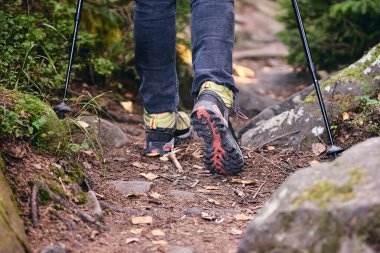 Yürüyüş botlarıyla dışarı çıkan bir kadın. Top View of Boot yolda. Kotlu bacaklar ve dağ ormanlarındaki kayalık kayalıklarda yürüyüş ayakkabıları.
