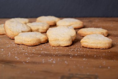 Tahta bir masada çeşitli şekillerde ev yapımı kurabiyeler.