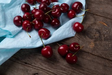 Tahta masadaki tabaklardan çıkan kırmızı kirazlar, makro.