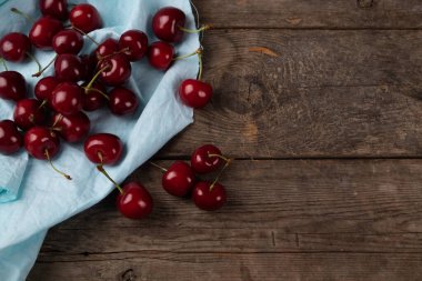 Tahta masadaki tabaklardan çıkan kırmızı kirazlar, makro.