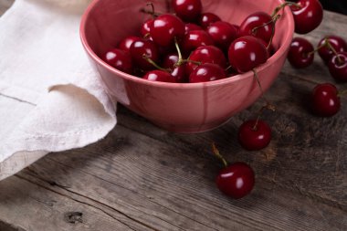 Tahta masadaki tabaklardan çıkan kırmızı kirazlar, makro.