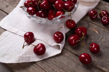 Tahta masadaki tabaklardan çıkan kırmızı kirazlar, makro.