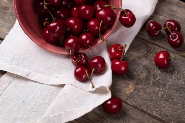 Tahta masadaki tabaklardan çıkan kırmızı kirazlar, makro.