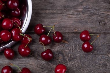 Tahta masadaki tabaklardan çıkan kırmızı kirazlar, makro.