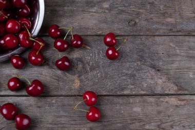 Tahta masadaki tabaklardan çıkan kırmızı kirazlar, makro.