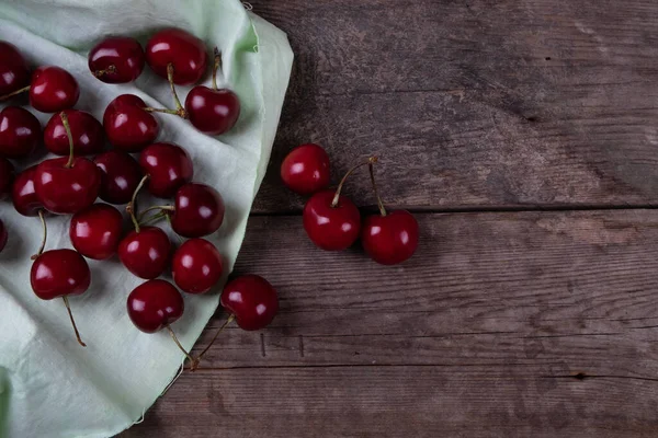 Rozrzucenie Czerwonych Wiśni Dań Drewnianym Stole Makro — Zdjęcie stockowe