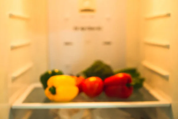 ぼかし写真 カラフルで多様な有機野菜のグループ ピーマンやピーマン グレー 赤と黄色の色 冷蔵庫のオレンジの光の下で棚に保つ — ストック写真