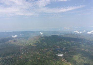 Gökyüzü manzarası uçaktan bulutlara temiz cam pencere koltuğu, beyaz kabarık bulutlar üzerinde seyahat ve güneşli bir günde yeryüzünün üzerinde canlı mavi gökyüzü 
