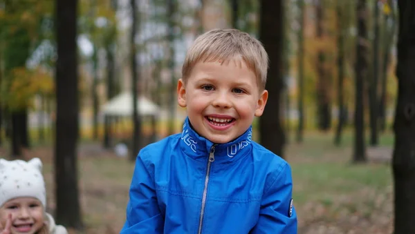 Ładny uśmiechający się portret chłopca na świeżym powietrzu w parku — Zdjęcie stockowe