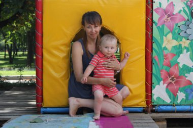 Genç Anne küçük bebek eğlence parkı ile mutlu bir aile gülümseyen