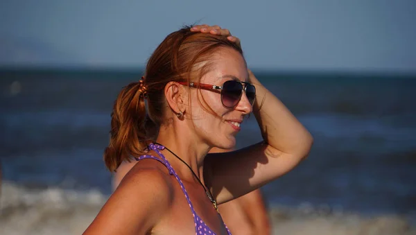 Красивая женщина в очках на пляже — стоковое фото
