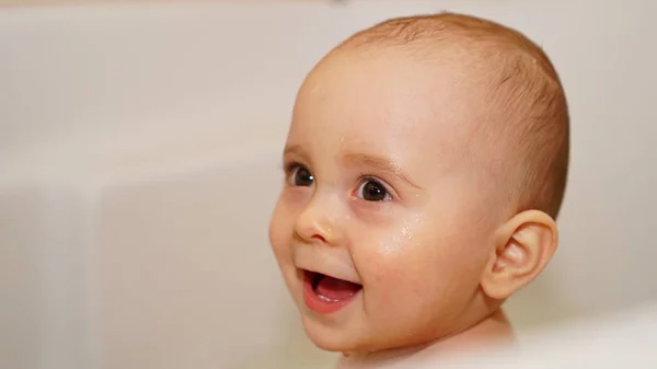 Bambino divertente che gioca con l'acqua in un bagno. Bagni per bambini . — Foto Stock