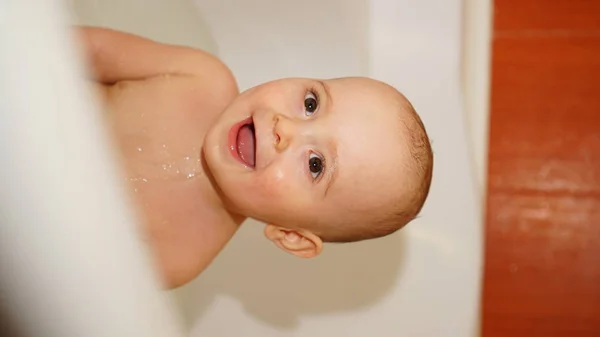 Bambino divertente che gioca con l'acqua in un bagno. Bagni per bambini . — Foto Stock