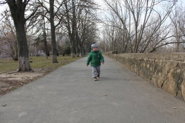 Sevimli çocuk çocuk için iyi bir hava ile parkta yürüyüş.