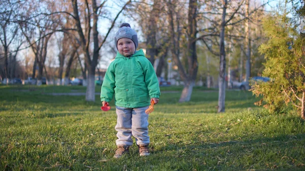 Mały chłopiec na zielonym trawniku jesienią z zabawkami — Zdjęcie stockowe