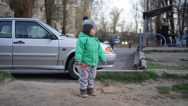 Petit garçon avec des jouets dans la rue près de la voiture dans la ville — Photo