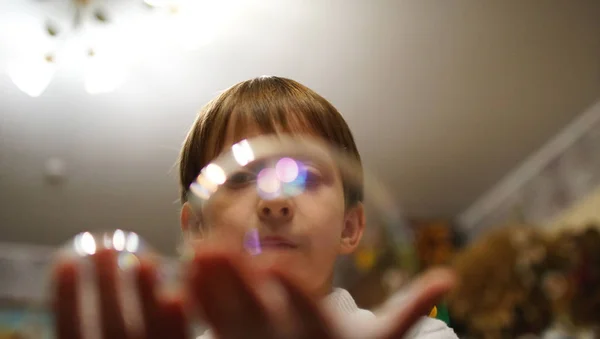 Мальчик держит мыльные пузыри на руке в кафе — стоковое фото