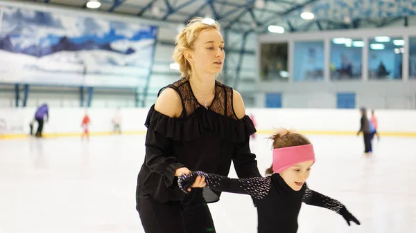 Eiskunstlauf-Trainerin trainiert kleines Mädchen in Eissporthalle — Stockfoto