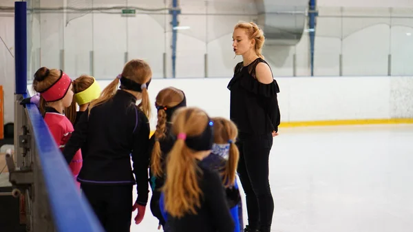 Eiskunstlauf-Trainerin spricht mit Mädchen in der Eishalle — Stockfoto