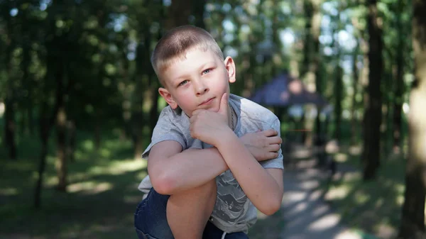 Portret van blanke tiener jongen. Grappig schattig tiener in zomerpark op dag. — Stockfoto