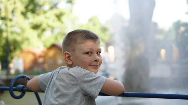 Bliska portret kaukaski chłopiec nastolatek. Zabawny nastolatek w letnim parku w dzień. — Zdjęcie stockowe