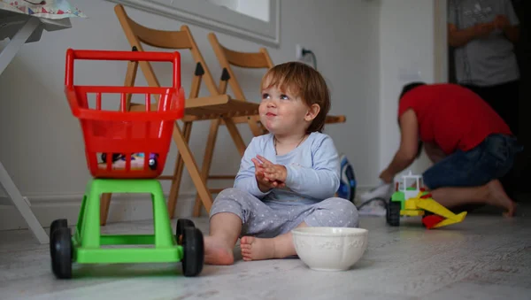 Cute little baby girl siedzi na liściastych i uśmiechnięty. — Zdjęcie stockowe