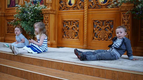 Boy and his little friends sitting on the step in the Orthodox Church.