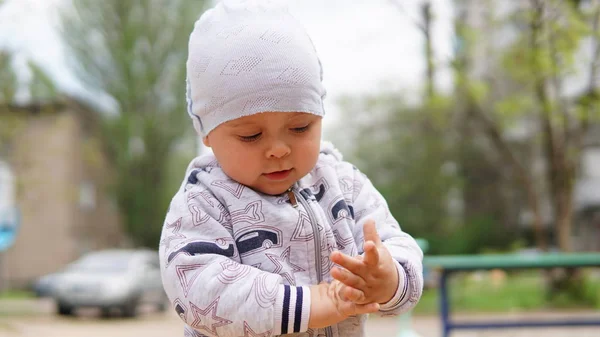 Urocza maluch w białym kapeluszu na zewnątrz na placu zabaw — Zdjęcie stockowe