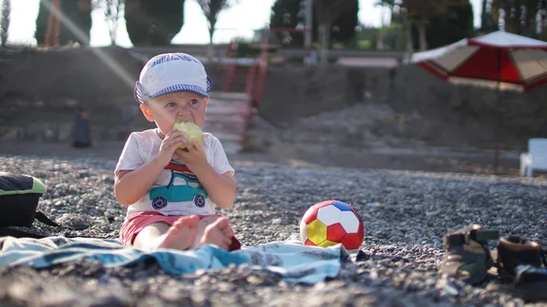 Küçük sevimli erkek bebek deniz kıyısında mat oturuyor — Stok fotoğraf