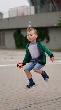 Küçük komik çocuk gri kaldırım ile kare atlar