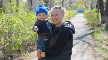 Anne ve çocuk çocuk için iyi hava ile parkta ayakta.