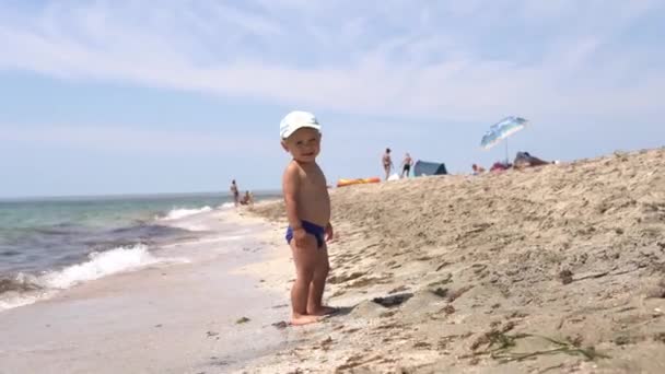 Carino Bambino Cappello Guardando Fotocamera Sorridendo Sulla Spiaggia Con Onde — Video Stock