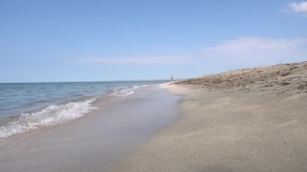海浪在海滩的沙滩上滚上岸 慢慢消失 柔和的波浪进出 水是干净的 在夏天的阳光下波浪是明亮的 — 图库视频影像