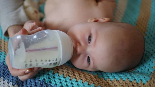 Carino bambino succhia il latte da una bottiglia — Foto Stock