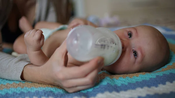 Bebê bonito chupa leite de uma mamadeira. Alimentando bebê — Fotografia de Stock