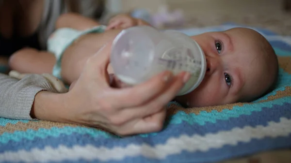 Bebê bonito chupa leite de uma mamadeira. Alimentando bebê — Fotografia de Stock