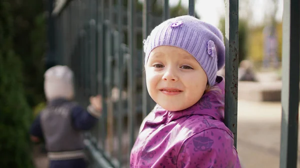 小可爱的女孩在公园的围栏上摆姿势在秋天. — 图库照片