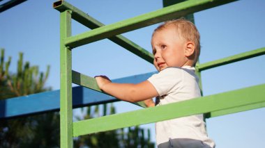 Sevimli çocuk bir oyun alanında korkuluk tutan