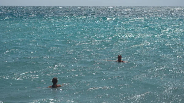 Zwei Personen schwimmen im ruhigen Meer Ozean und blauem Himmel Hintergrund — Stockfoto