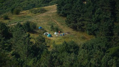 Dağlarda çayır arasında kampta turist çadırları